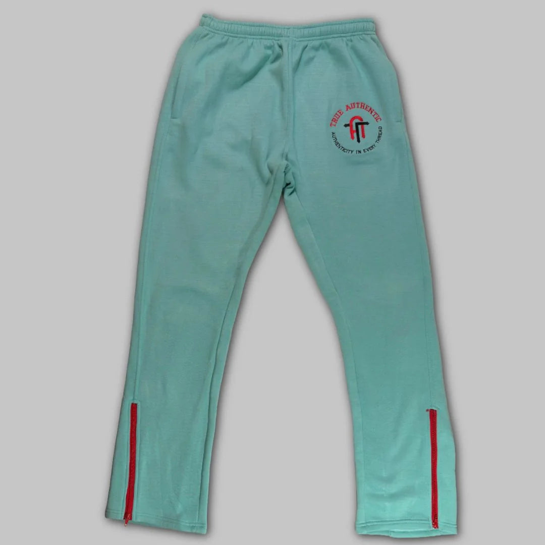 Front view of mint green True Authentic men's sweatpants featuring red ankle zippers and a signature TA monogram embroidered on the thigh.