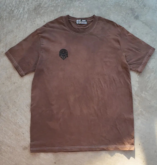 Brown t-shirt with a logo on a concrete floor