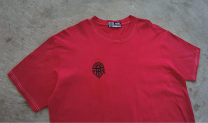 Red t-shirt with a black logo on a gray surface