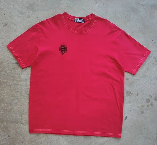 Red t-shirt with a logo on a concrete floor