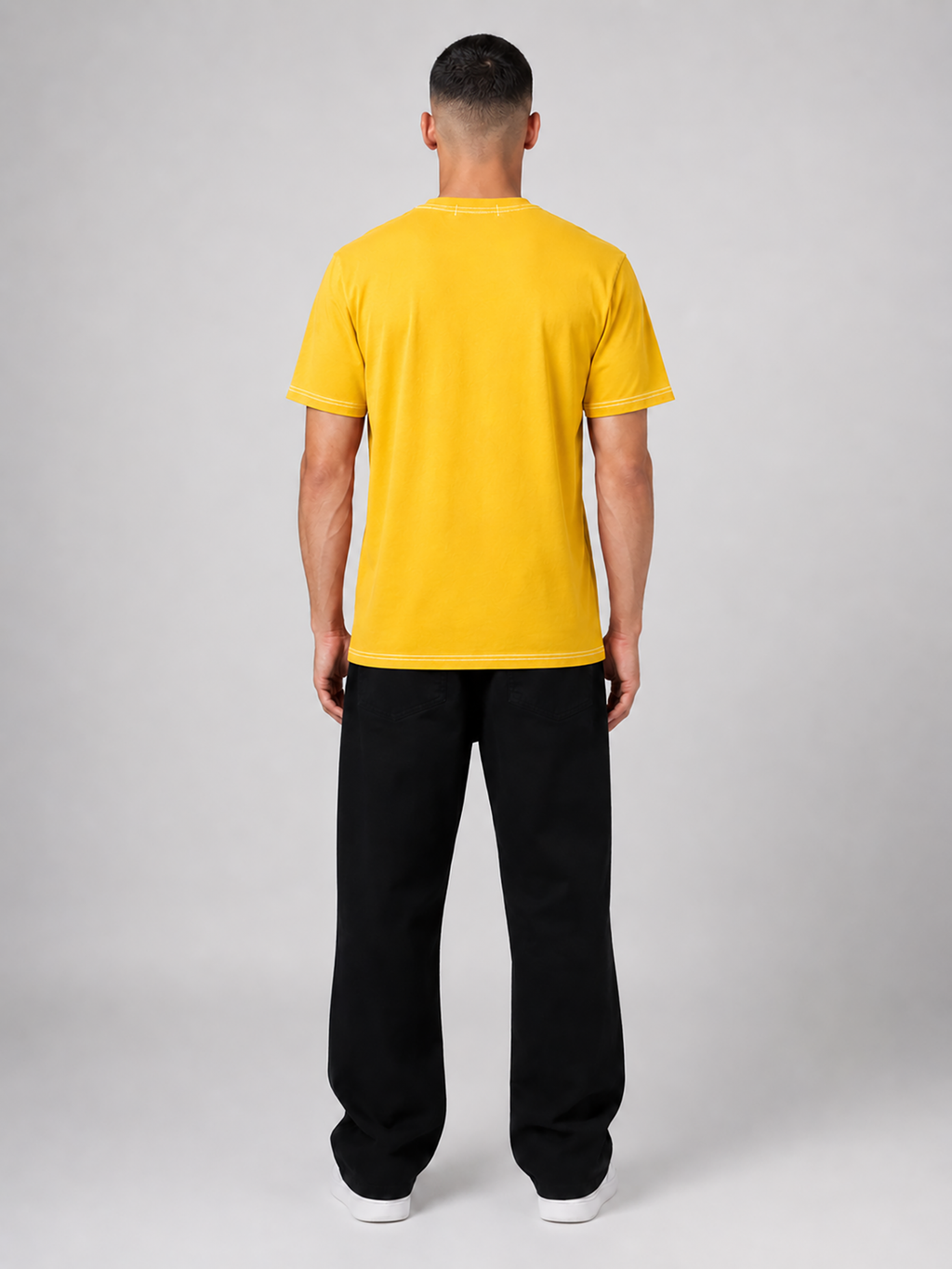 Person wearing a yellow t-shirt and black pants on a white background