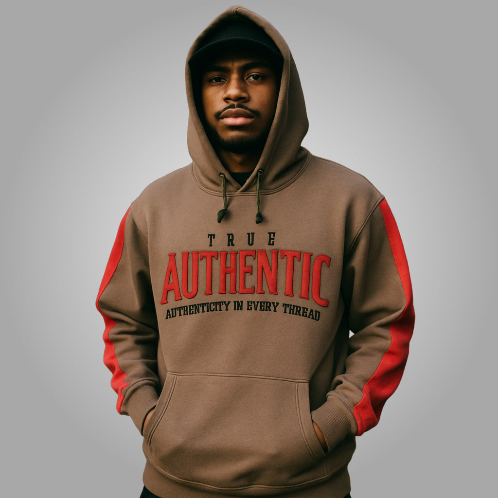 Man wearing a brown hoodie with red sleeves and 'True Authentic' text on a gray background