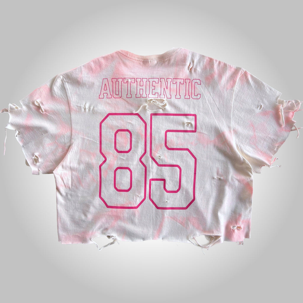White and pink tie-dye crop top with 'Authentic 85' text on a light gray background