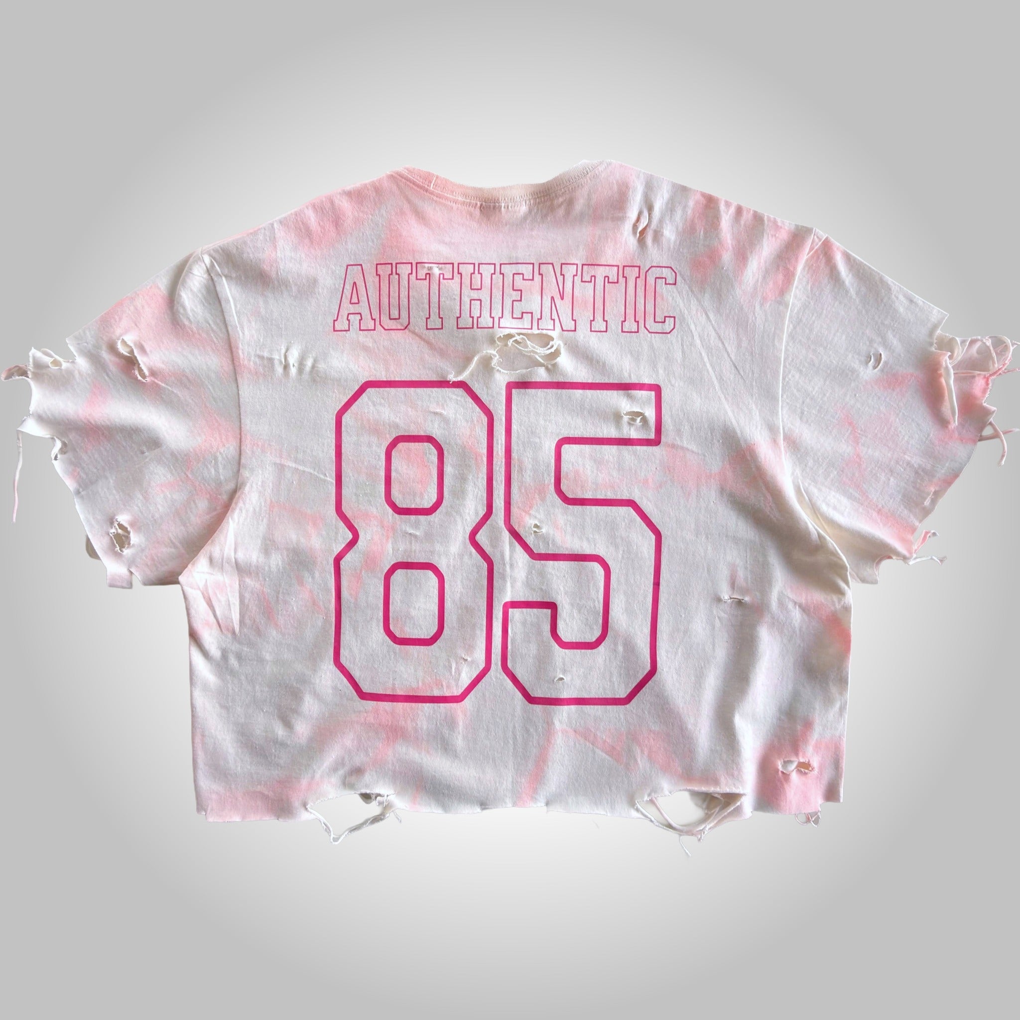 White and pink tie-dye crop top with 'Authentic 85' text on a light gray background