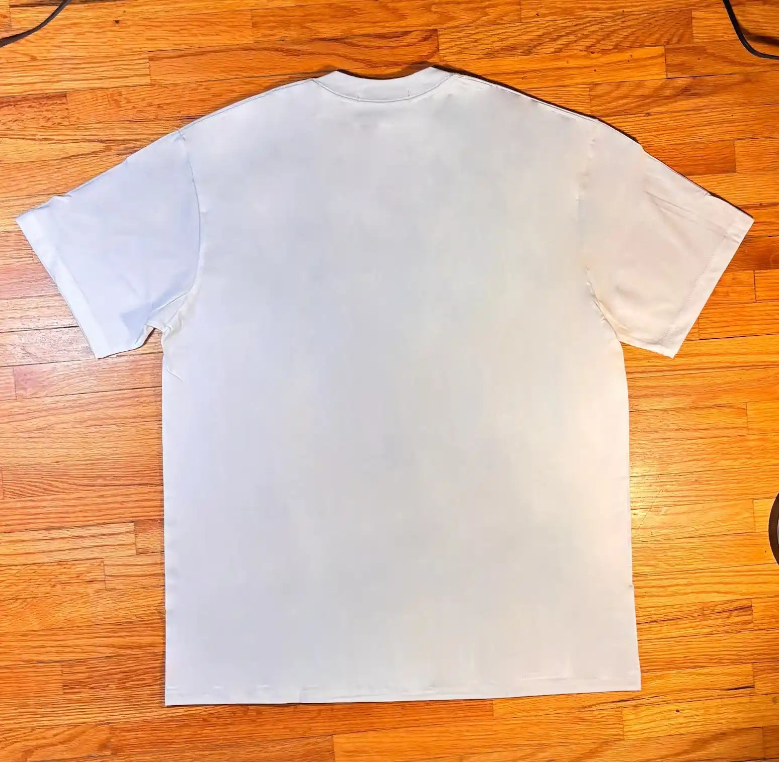 White t-shirt on a wooden floor