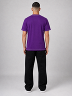 Person wearing a purple t-shirt and black pants on a gray background