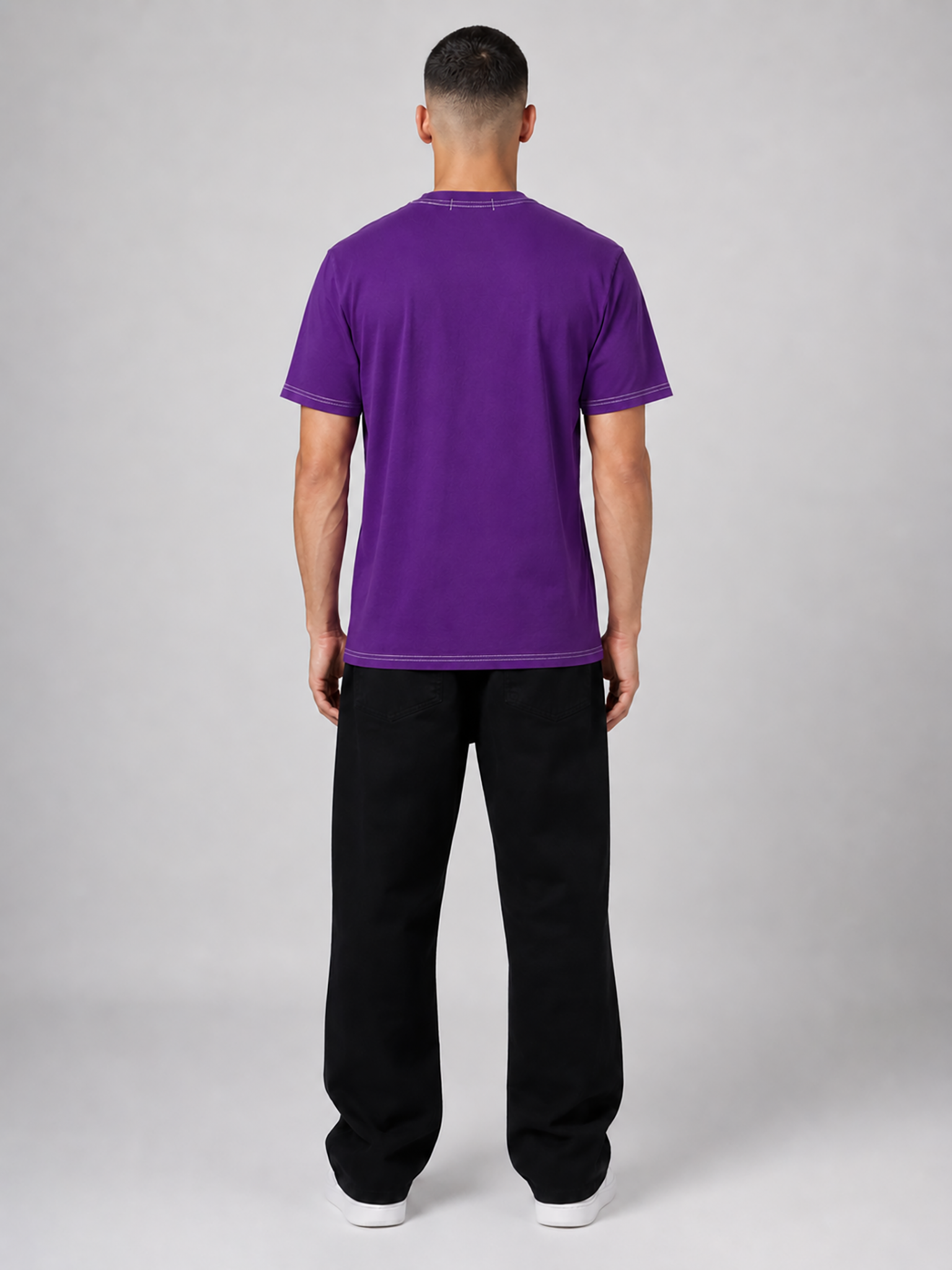 Person wearing a purple t-shirt and black pants on a gray background