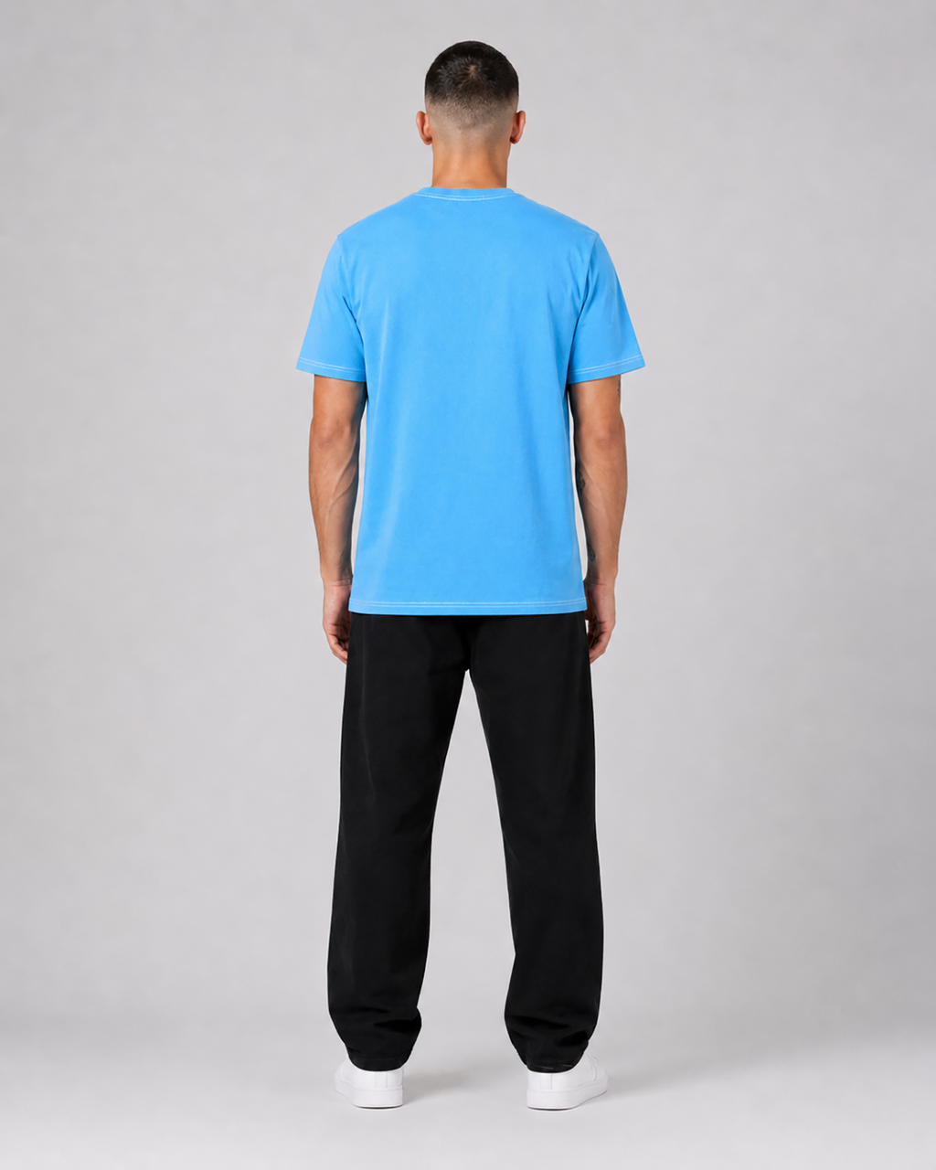 Person wearing a blue t-shirt and black pants on a gray background