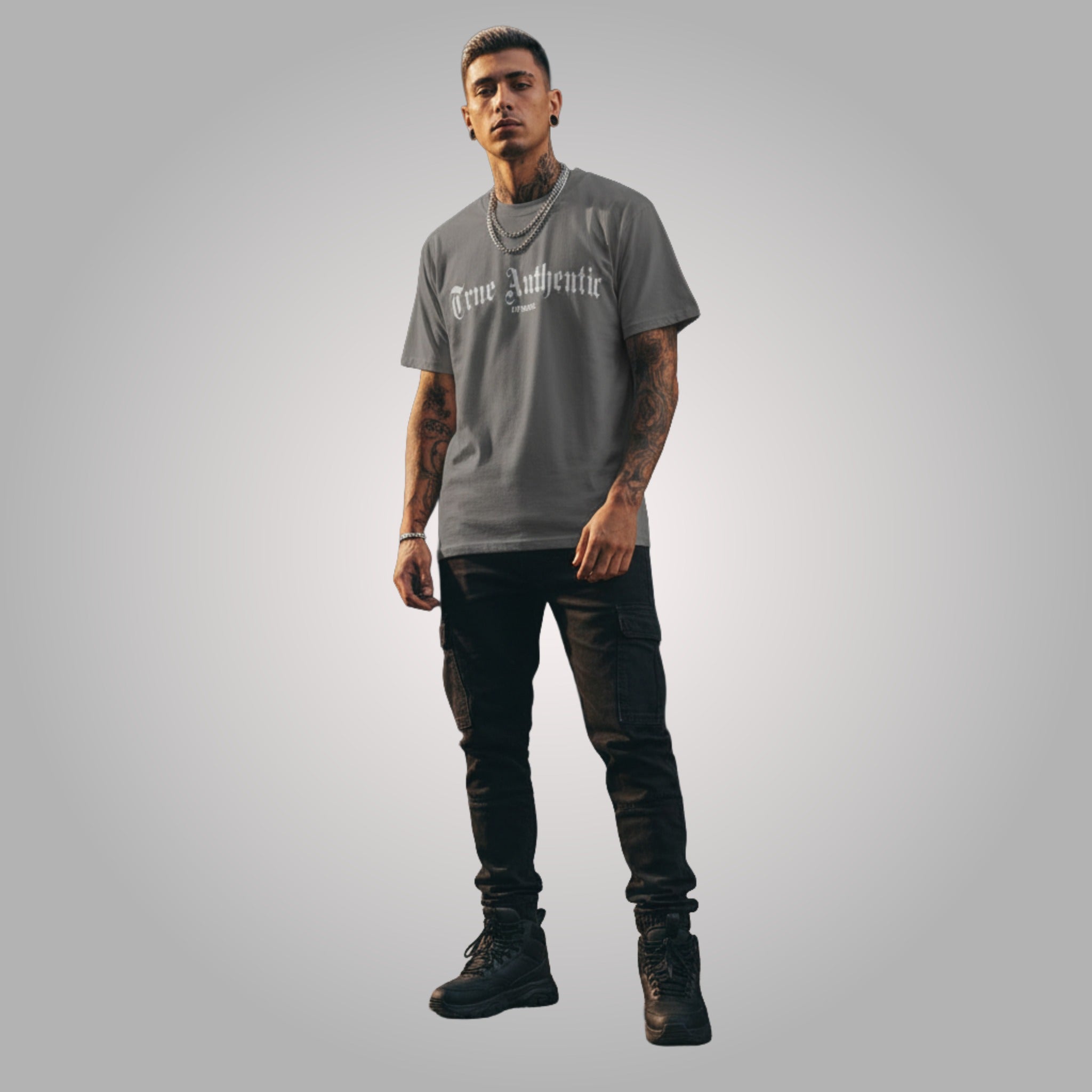 Person wearing a gray 'True Authentic' t-shirt and black pants on a gray background