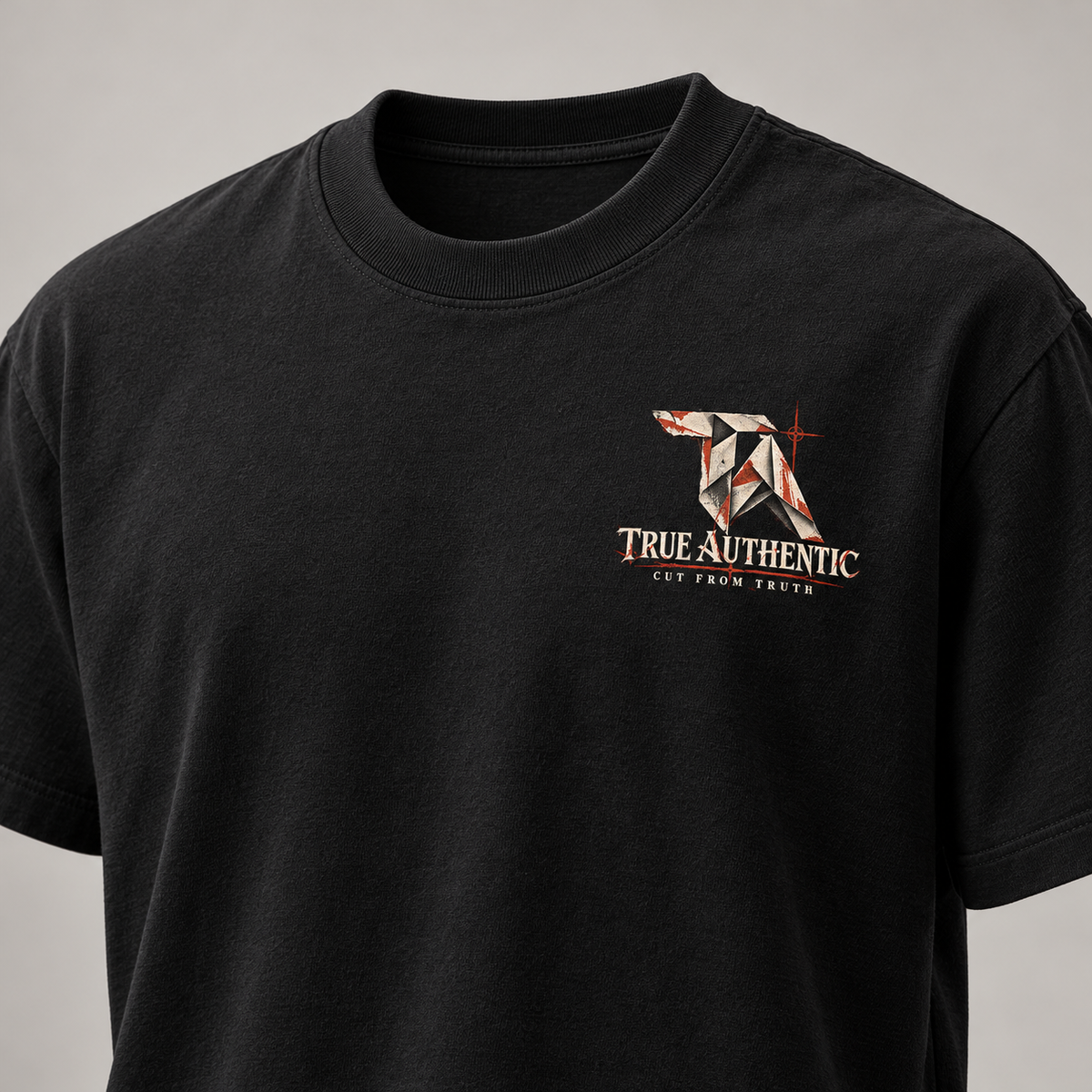TRUE AUTHENTIC cut from truth black cotton graphic tee — small left chest logo, close-up
