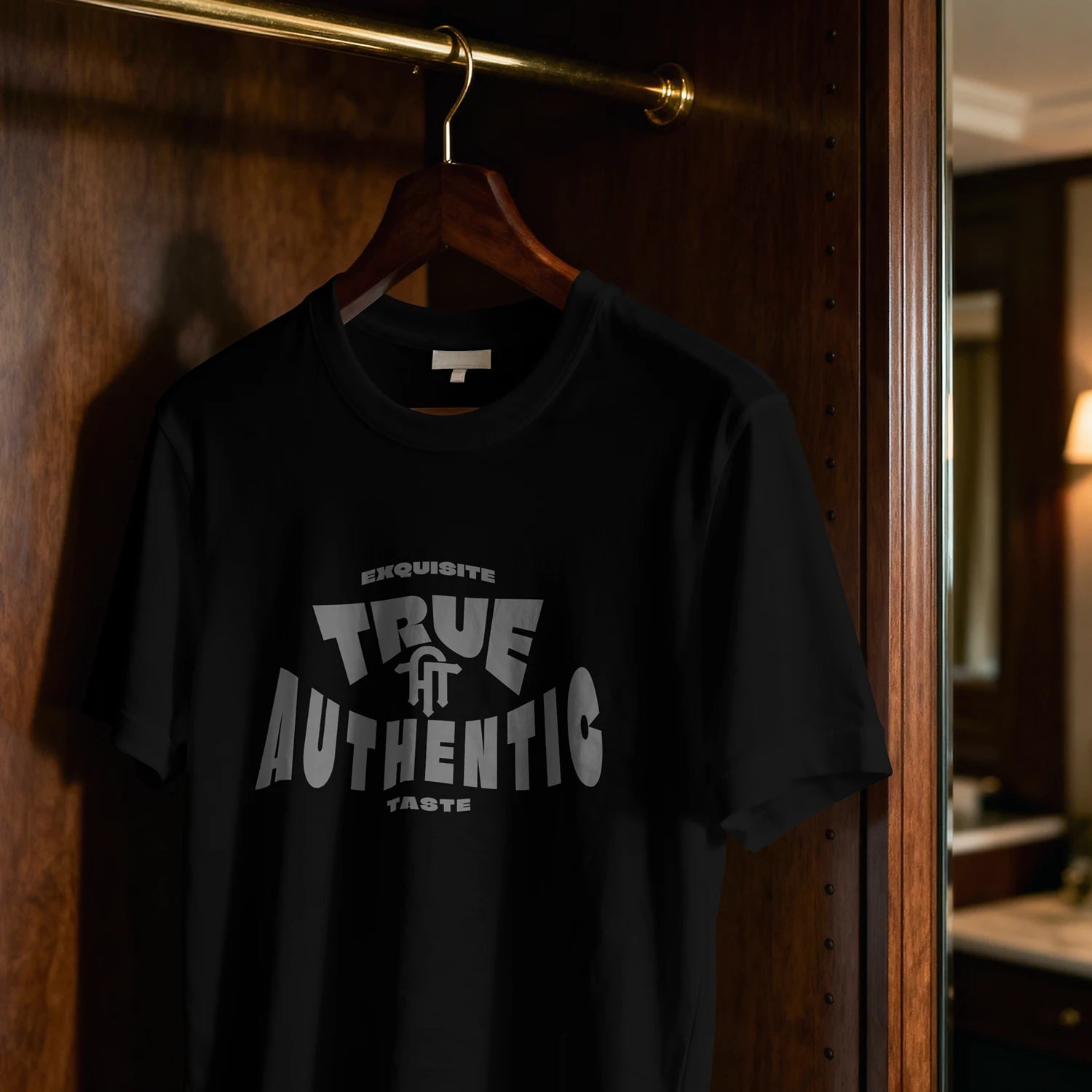 Black t-shirt with 'True Authentic' text on a hanger against a wooden door.