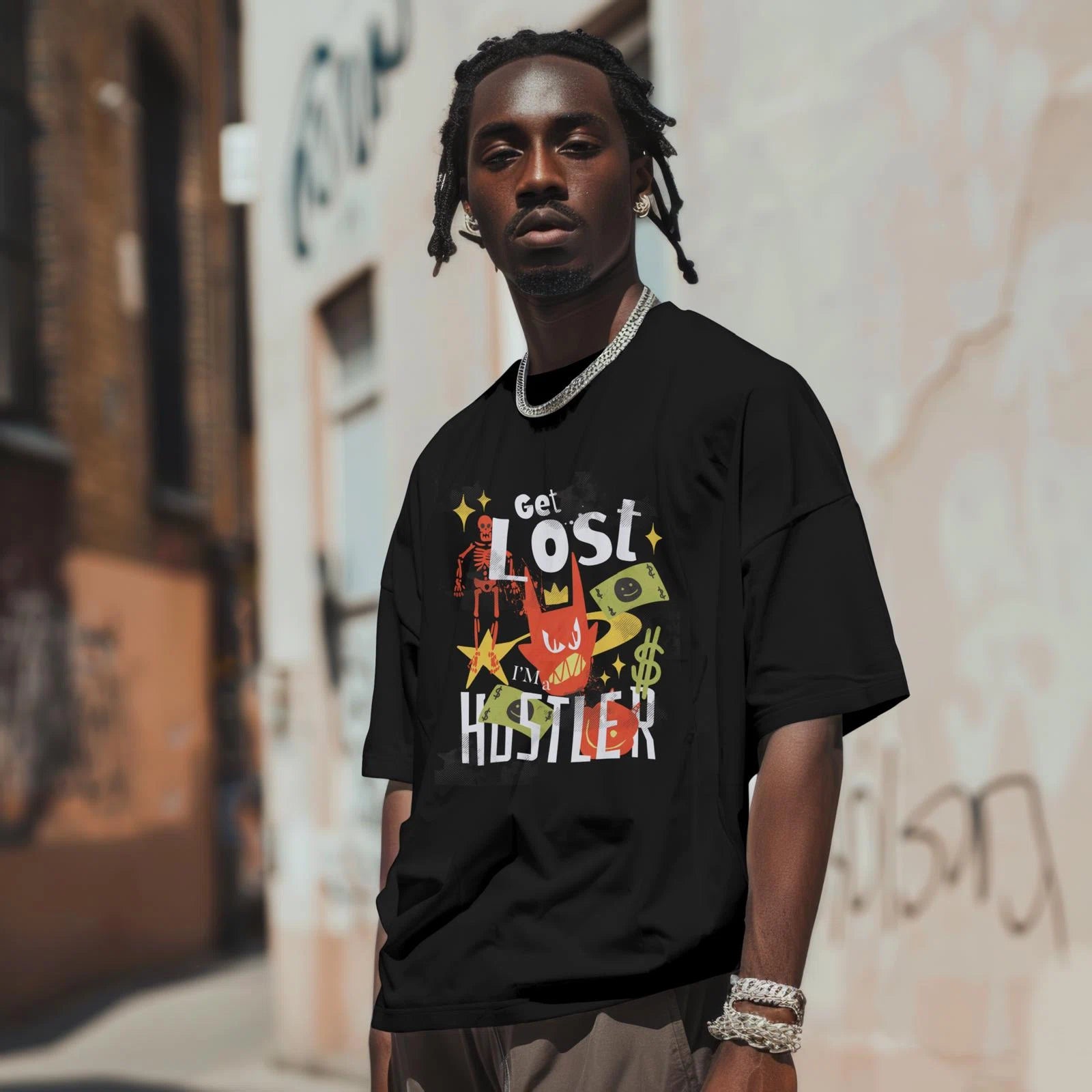 Man wearing a black t-shirt with colorful graphics and text, standing in an urban setting.