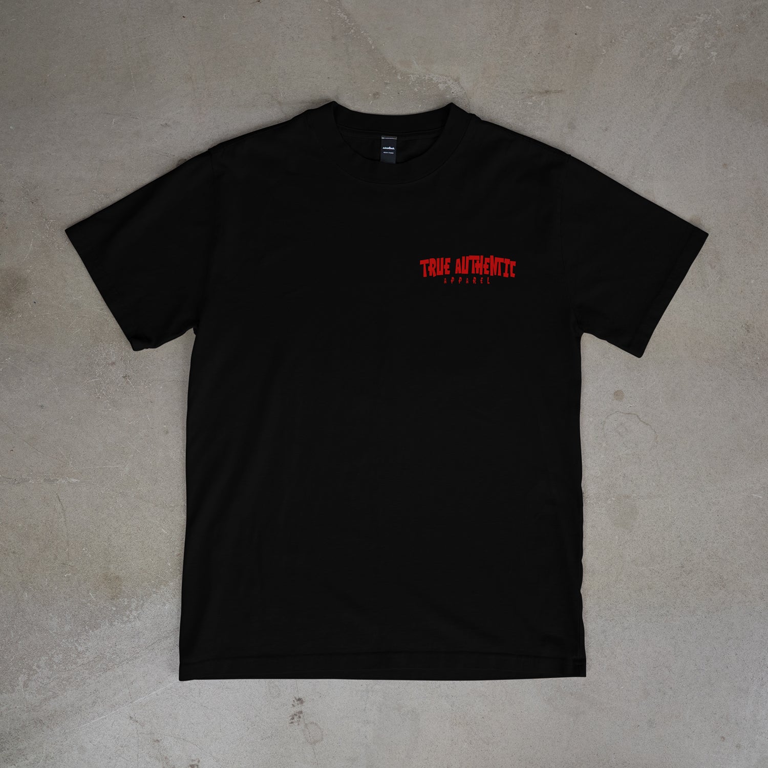 Black t-shirt with red text on a gray surface