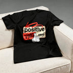Black t-shirt with a graphic design on a beige couch