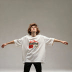 Person wearing a white t-shirt with a red and black graphic design on a gray background