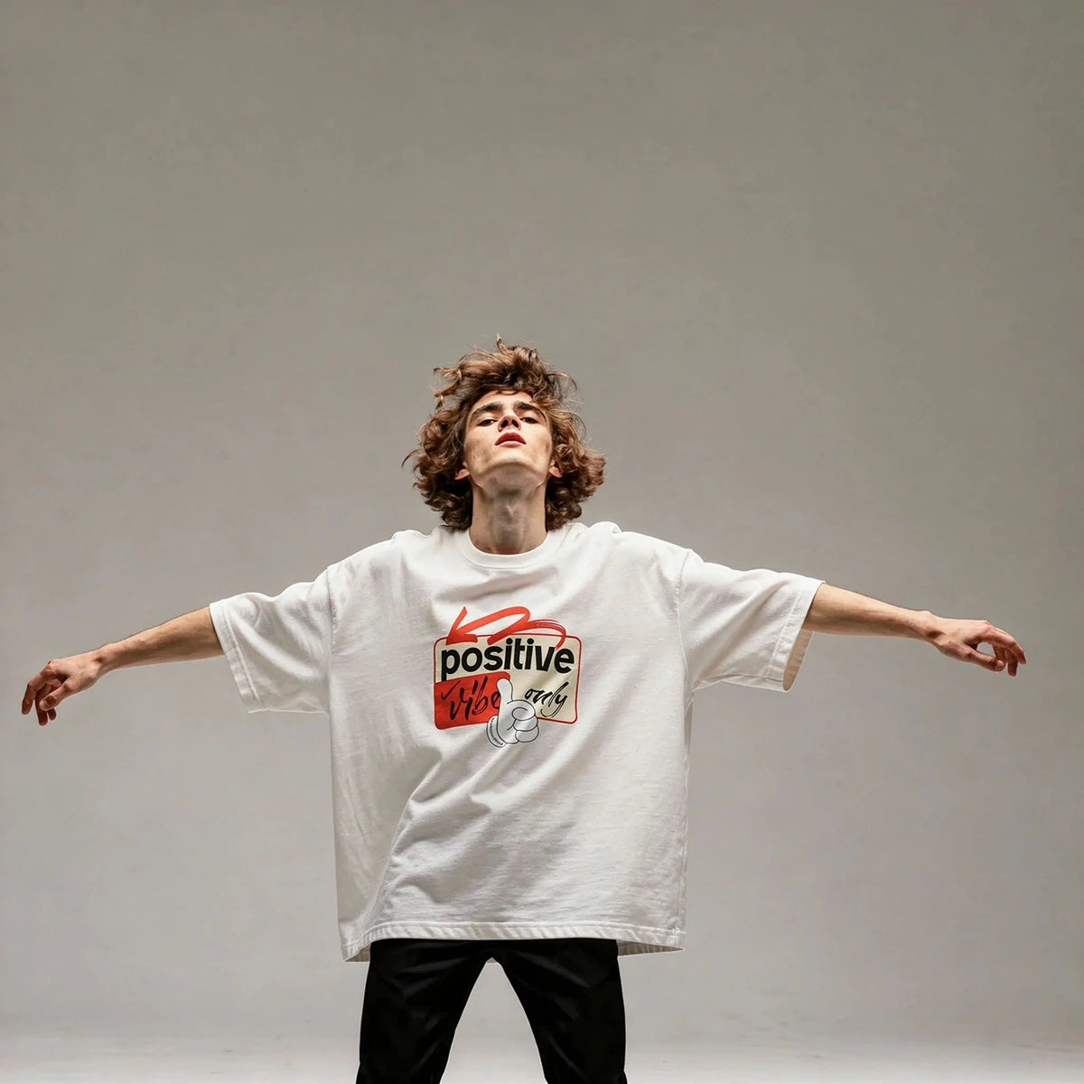 Person wearing a white t-shirt with a red and black graphic design on a gray background