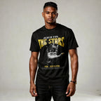 Man wearing a black t-shirt with 'Reach for the Stars' text and graphic design.