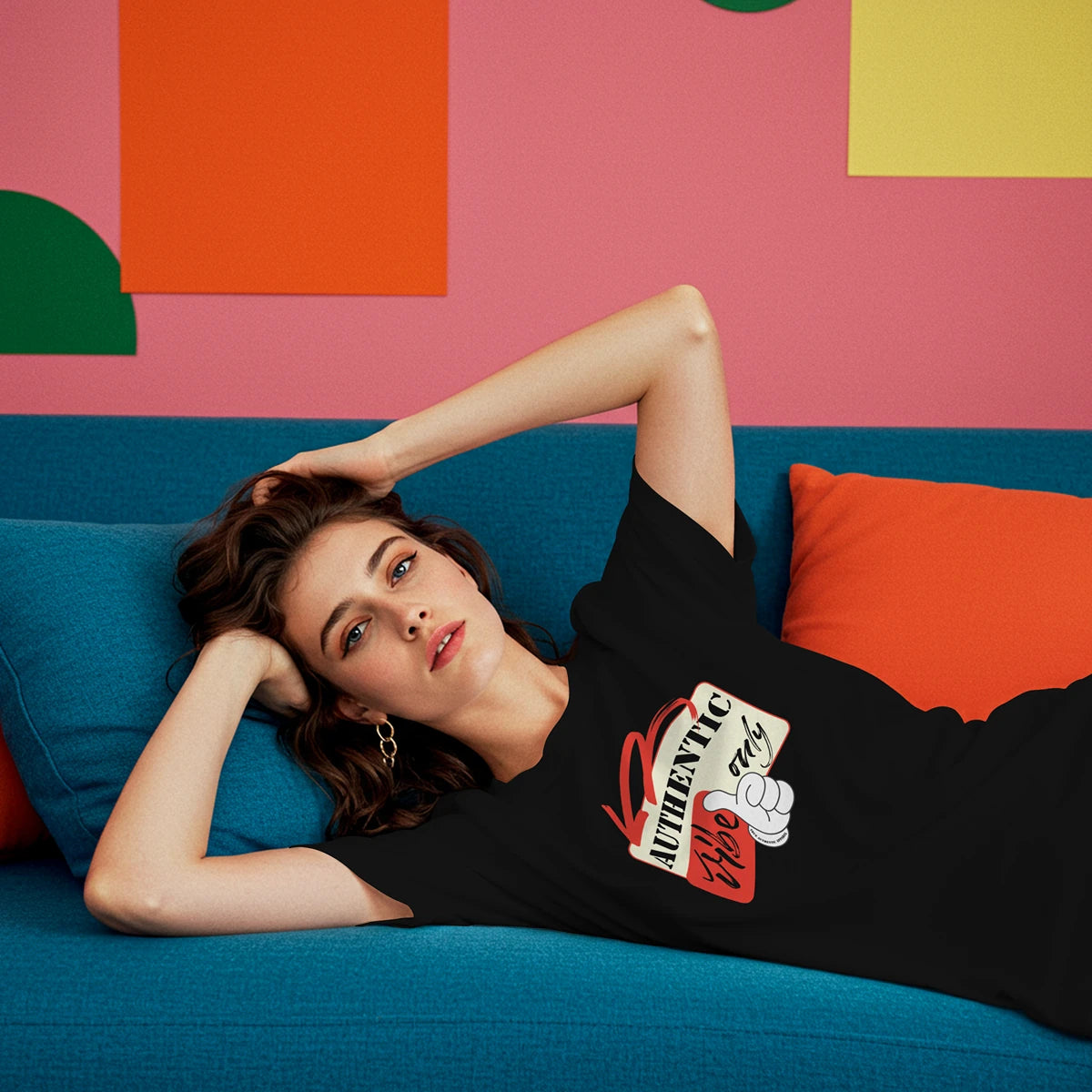 Woman lying on a blue couch against a colorful geometric wall